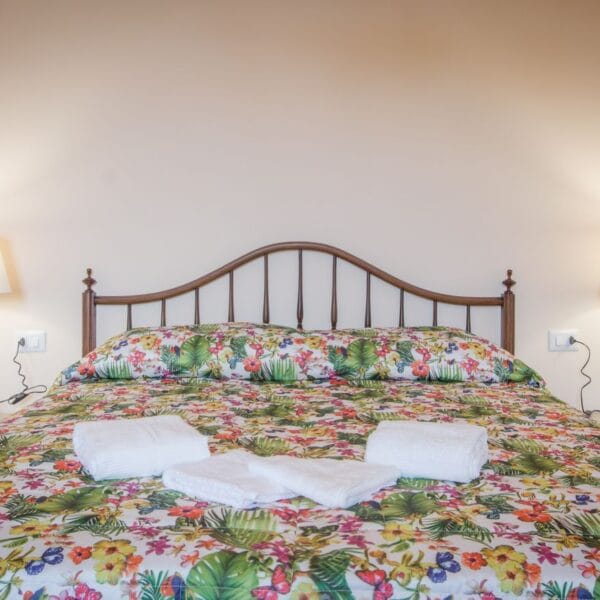 Apartment RED bedroom with wooden headboard, San Frediano, Florence